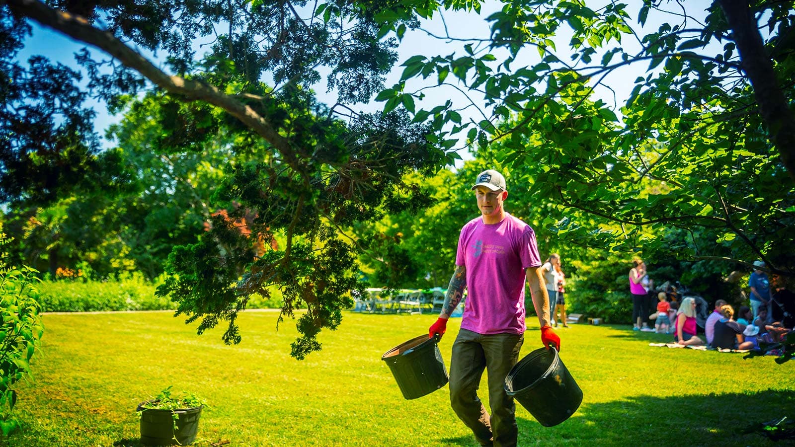 team member carrying pots in a field at a staff picnic