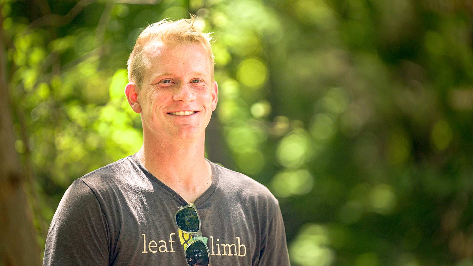 Luke wearing a grey Leaf & Limb shirt, smiling at the camera.